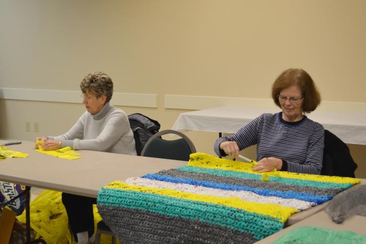 Boyd County Extension Homemaker Debbie Hoback, left, hook together tpgether pieces of plastic bags to make "plarn" while fellow Extension Homemaker Lana Plymale crochets one of the mats. Photo by Katie Pratt, UK agricultural communications.